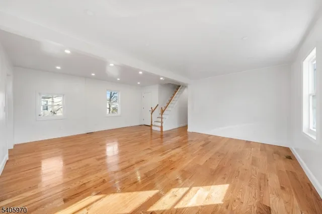 a view of a big room with wooden floor and a window
