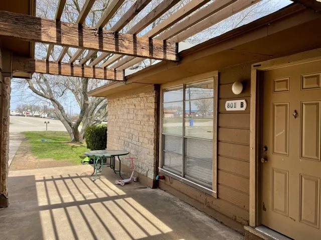 a view of a porch with a table and chairs