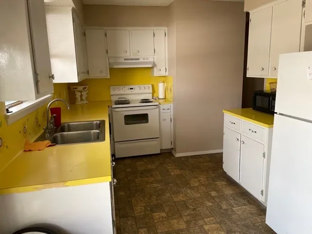 a utility room with cabinets washer and dryer