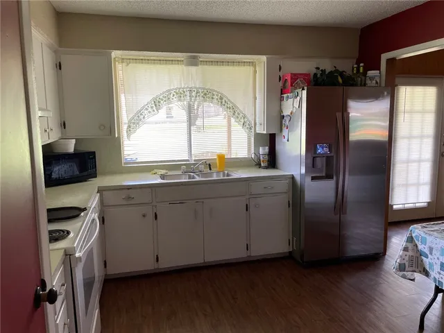 a kitchen with stainless steel appliances a refrigerator sink and cabinets