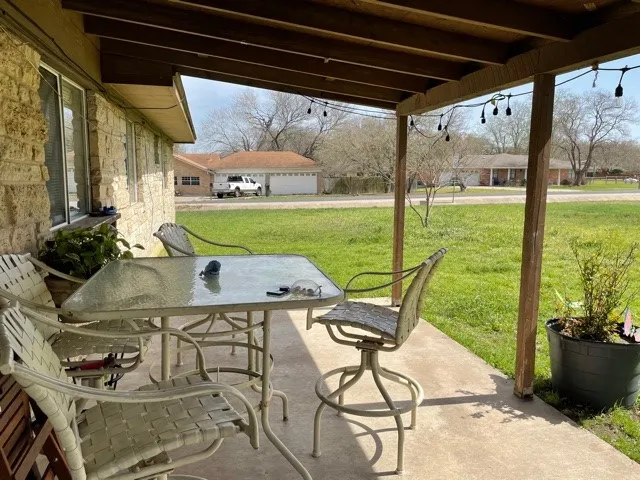 a patio with table and chairs with potted plants