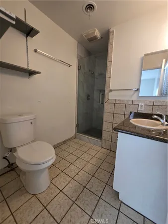 a bathroom with a granite countertop toilet and a sink