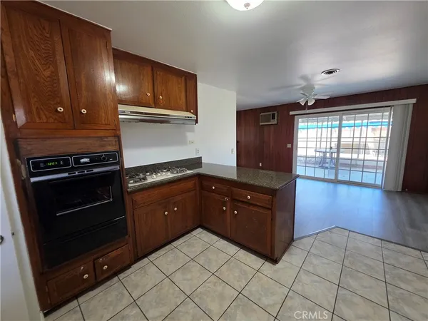 a kitchen with stainless steel appliances granite countertop a stove a refrigerator and wooden cabinets