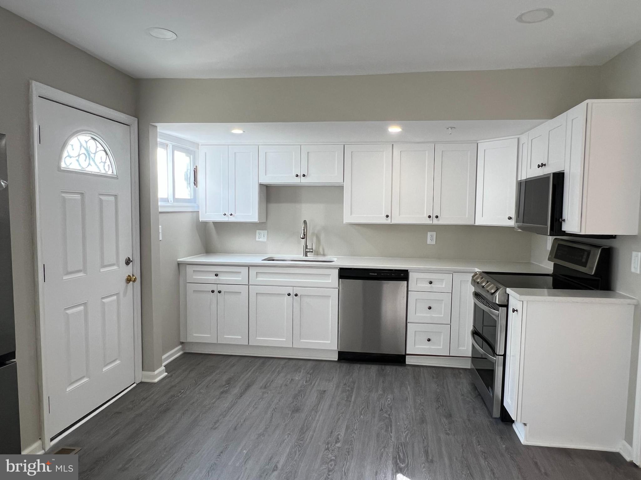 805 Spa Road Annapolis, MD 21401 - Photo 30 of 47 a kitchen with a white cabinets and wooden floor