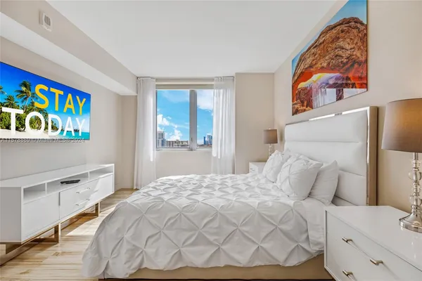 a bedroom with a bed and a tv on the dresser