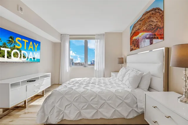 a bedroom with a bed and a tv on the dresser