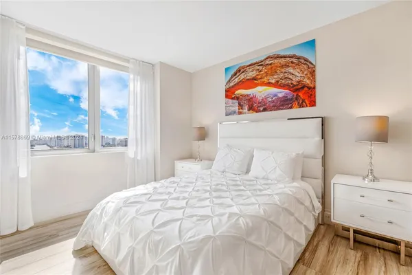 a bedroom with a bed and a painting on the wall