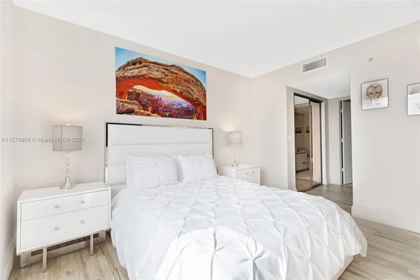 a bedroom with a bed and a painting on the wall