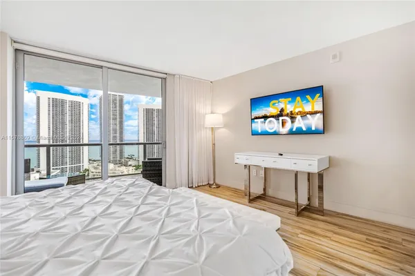 a bedroom with a bed and a flat screen tv