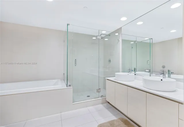 a spacious bathroom with a shower sink and mirror