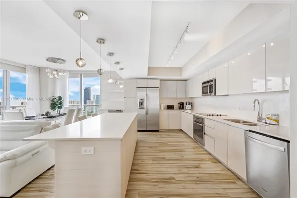 a large kitchen with kitchen island a sink a stove a center island and cabinets