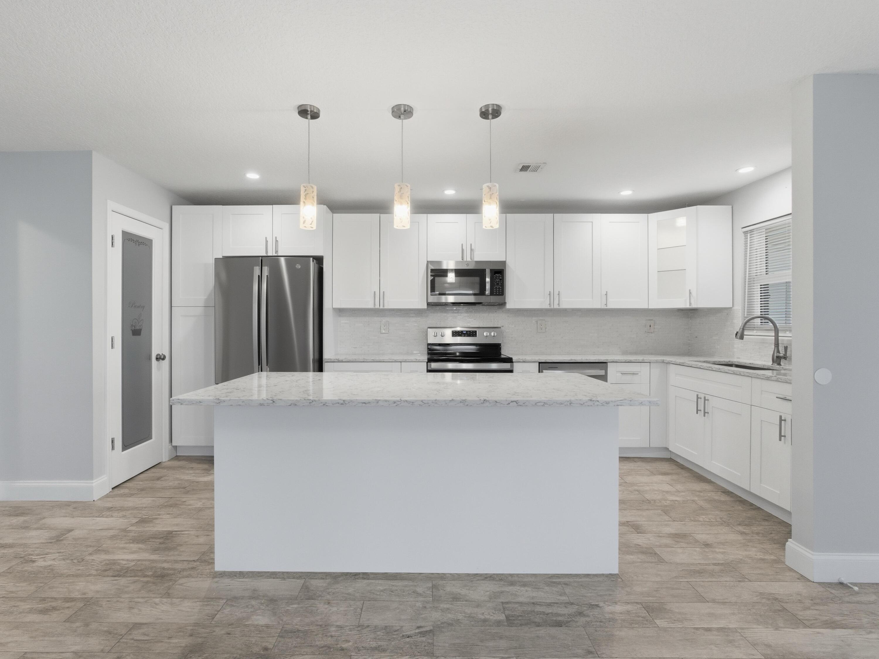 270 High Point Boulevard, Unit A Boynton Beach, FL 33435 - Photo 18 of 44 a kitchen with stainless steel appliances a refrigerator sink and microwave
