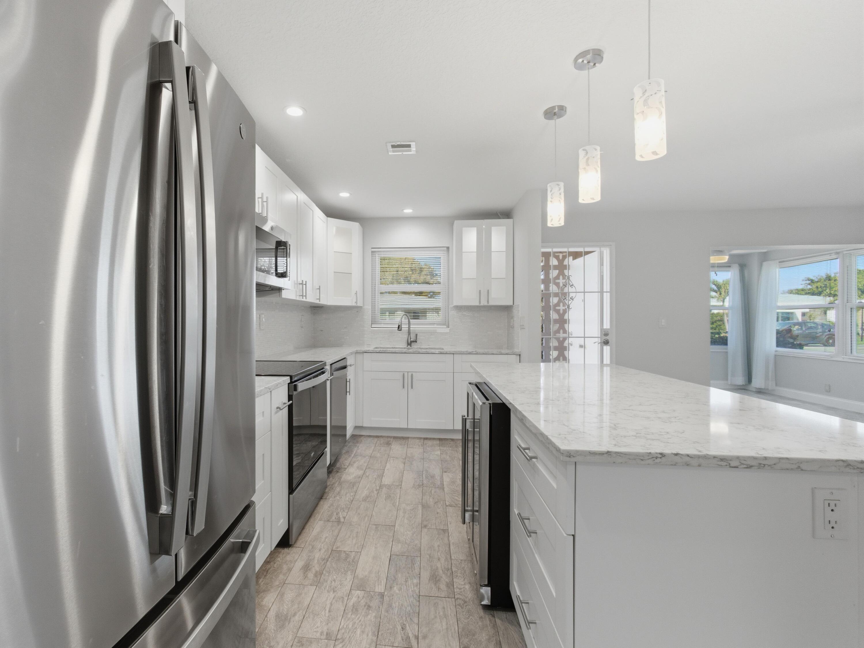 270 High Point Boulevard, Unit A Boynton Beach, FL 33435 - Photo 19 of 44 a kitchen with kitchen island a counter top space a sink stainless steel appliances and cabinets