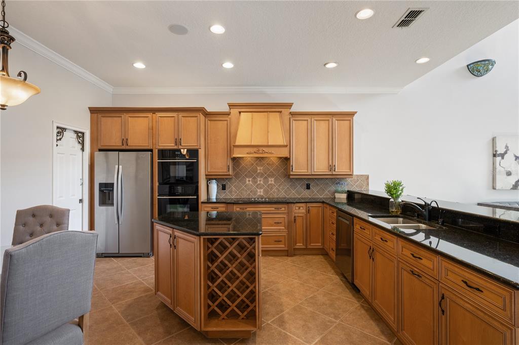 8119 Vía Rosa Orlando, FL 32836 - Photo 12 of 62 a kitchen with stainless steel appliances kitchen island granite countertop a sink refrigerator and cabinets
