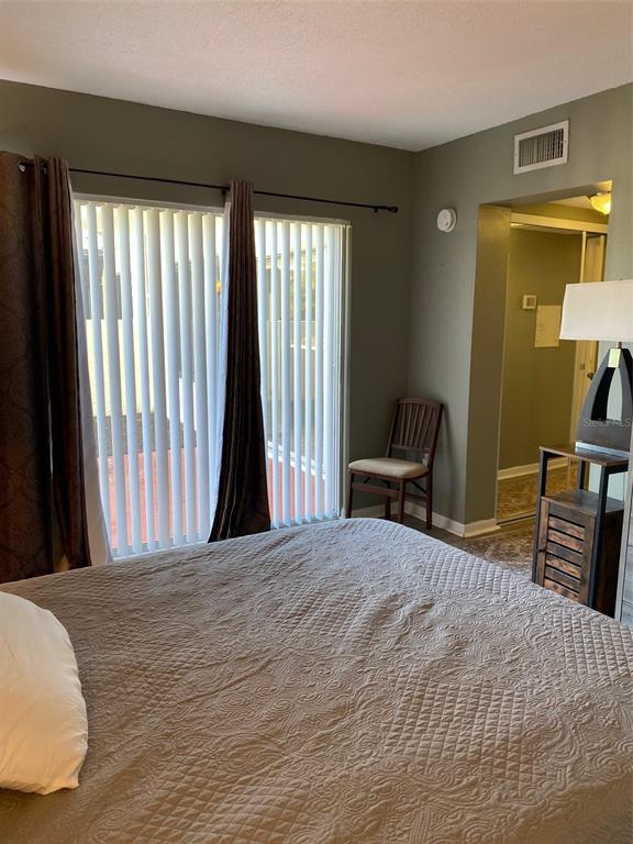 2209 Belleair Road, Unit C21 Clearwater, FL 33764 - Photo 12 of 23 a bedroom with a bed and wooden floor