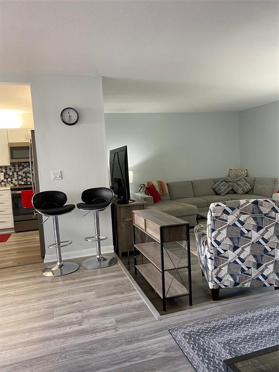 2209 Belleair Road, Unit C21 Clearwater, FL 33764 - Photo 6 of 23 a bedroom with furniture and a wooden floor