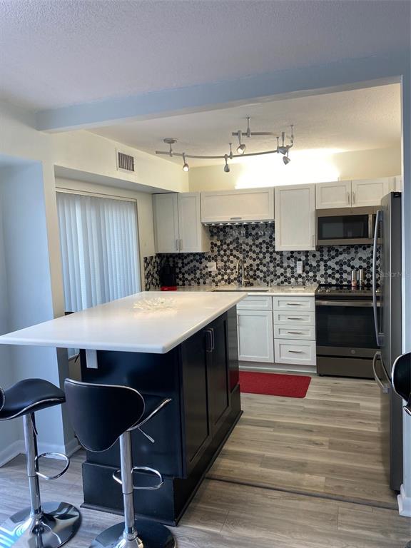 2209 Belleair Road, Unit C21 Clearwater, FL 33764 - Photo 9 of 23 a kitchen with stainless steel appliances granite countertop a sink stove and cabinets