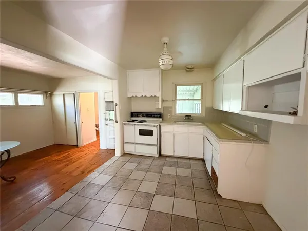 a large white kitchen with a stove a sink dishwasher and a refrigerator