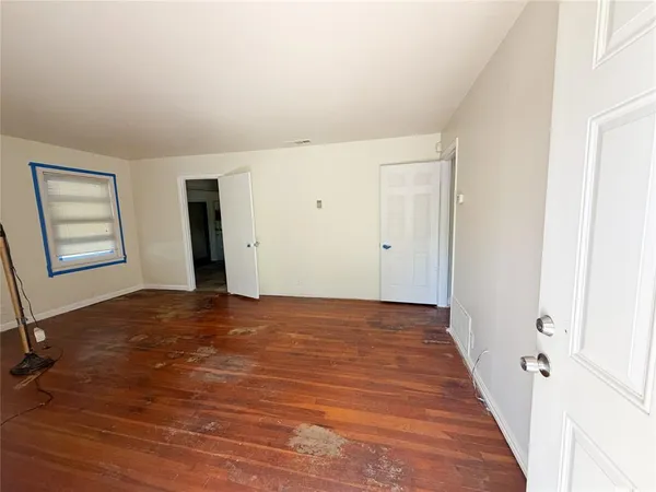 an empty room with windows and closet