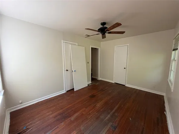 a view of empty room with wooden floor