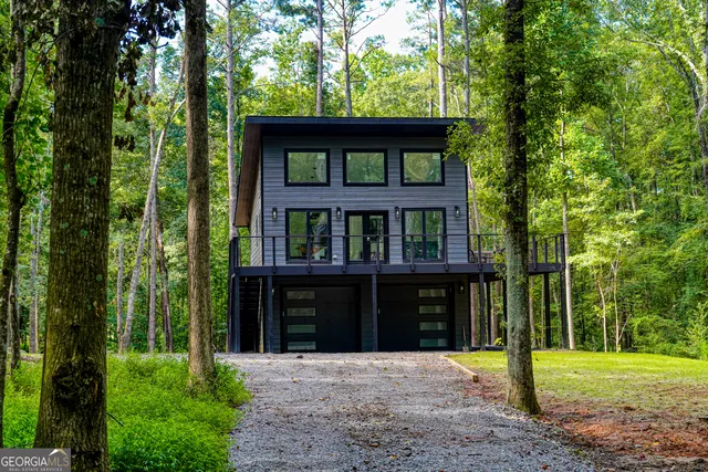 a view of a big yard with plants and large trees