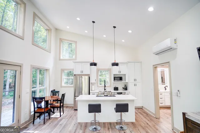 a view of a kitchen with kitchen island stainless steel appliances a table and chairs