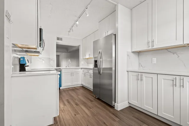 a kitchen with cabinets and a refrigerator