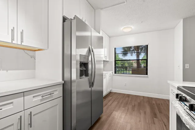 a kitchen with white cabinets and sink