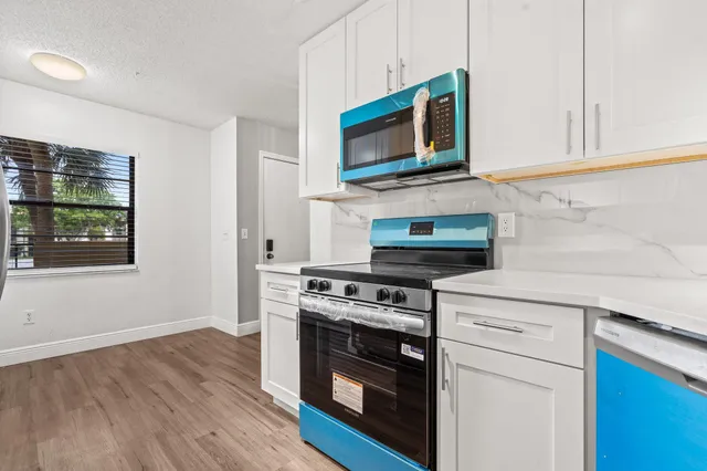 a kitchen with stainless steel appliances a refrigerator and a window