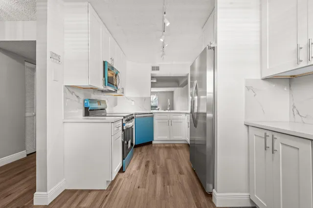 a kitchen with stainless steel appliances a refrigerator sink and cabinets