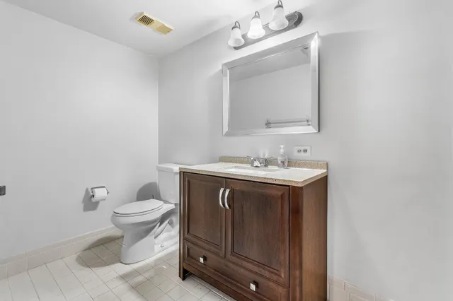 a bathroom with a sink vanity and a toilet