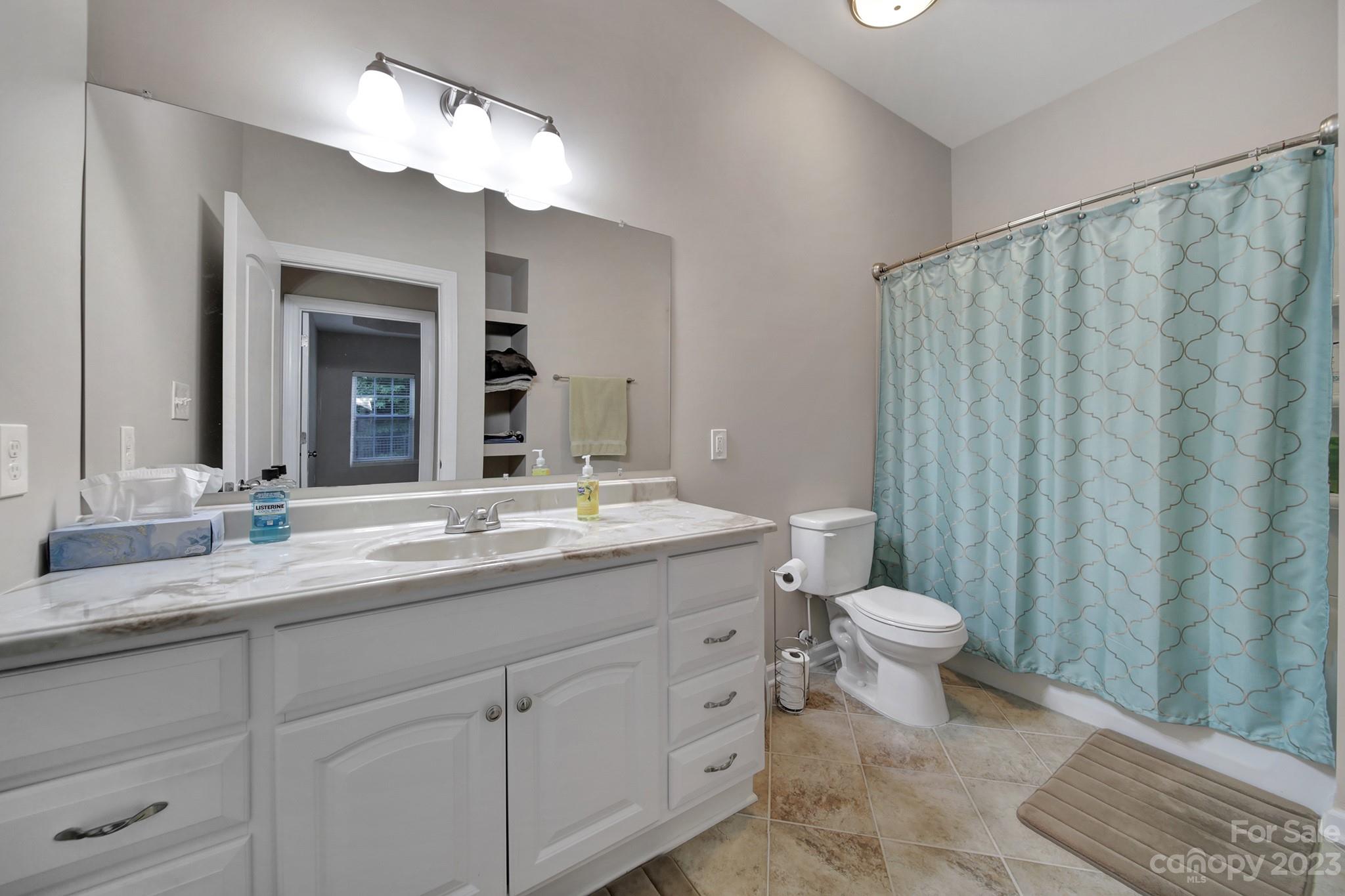818 Treasure Court Fort Mill, SC 29708 - Photo 28 of 47 a bathroom with a granite countertop sink toilet a mirror and a shower