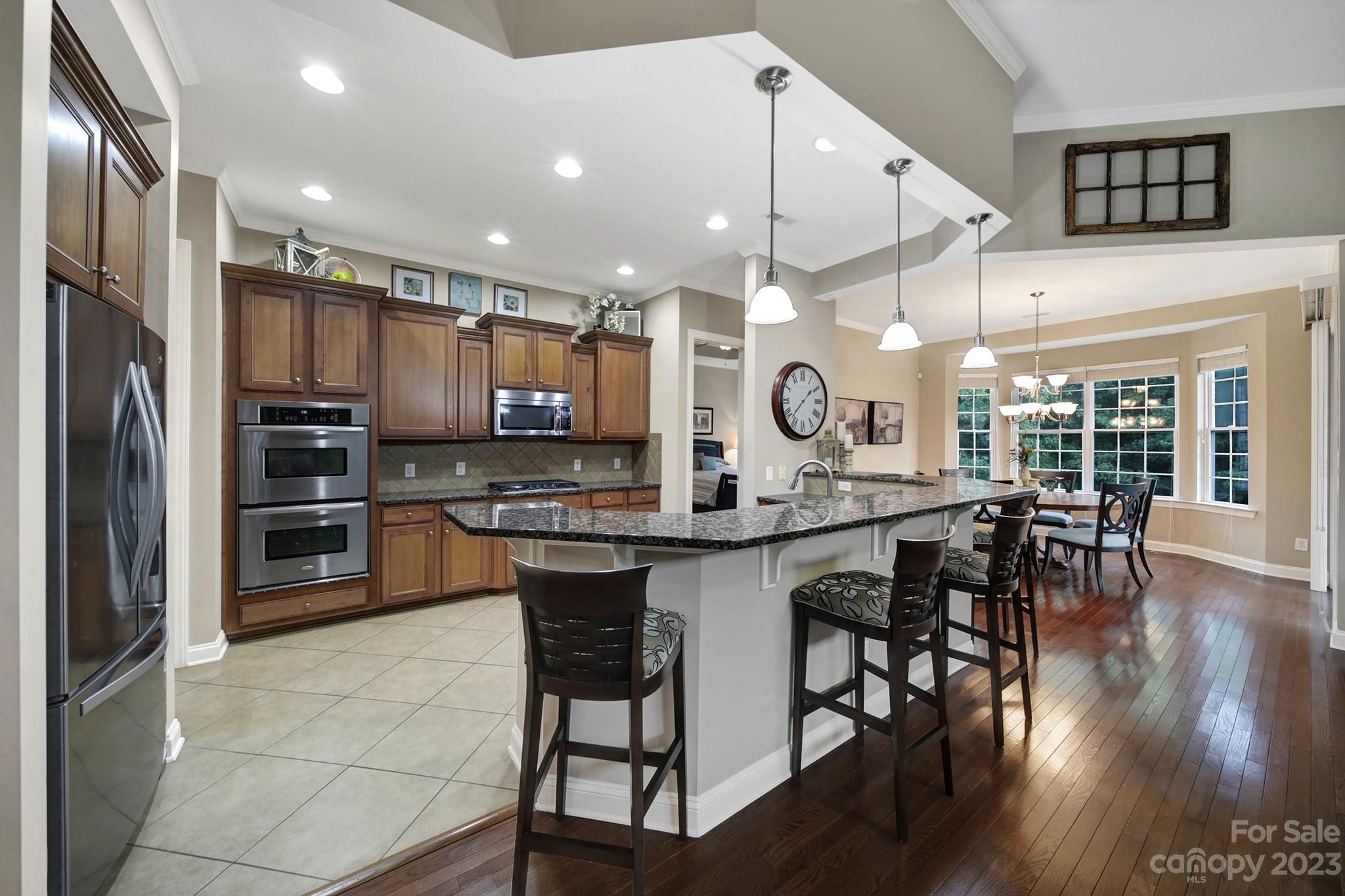 818 Treasure Court Fort Mill, SC 29708 - Photo 6 of 47 a kitchen with granite countertop a table chairs microwave and cabinets