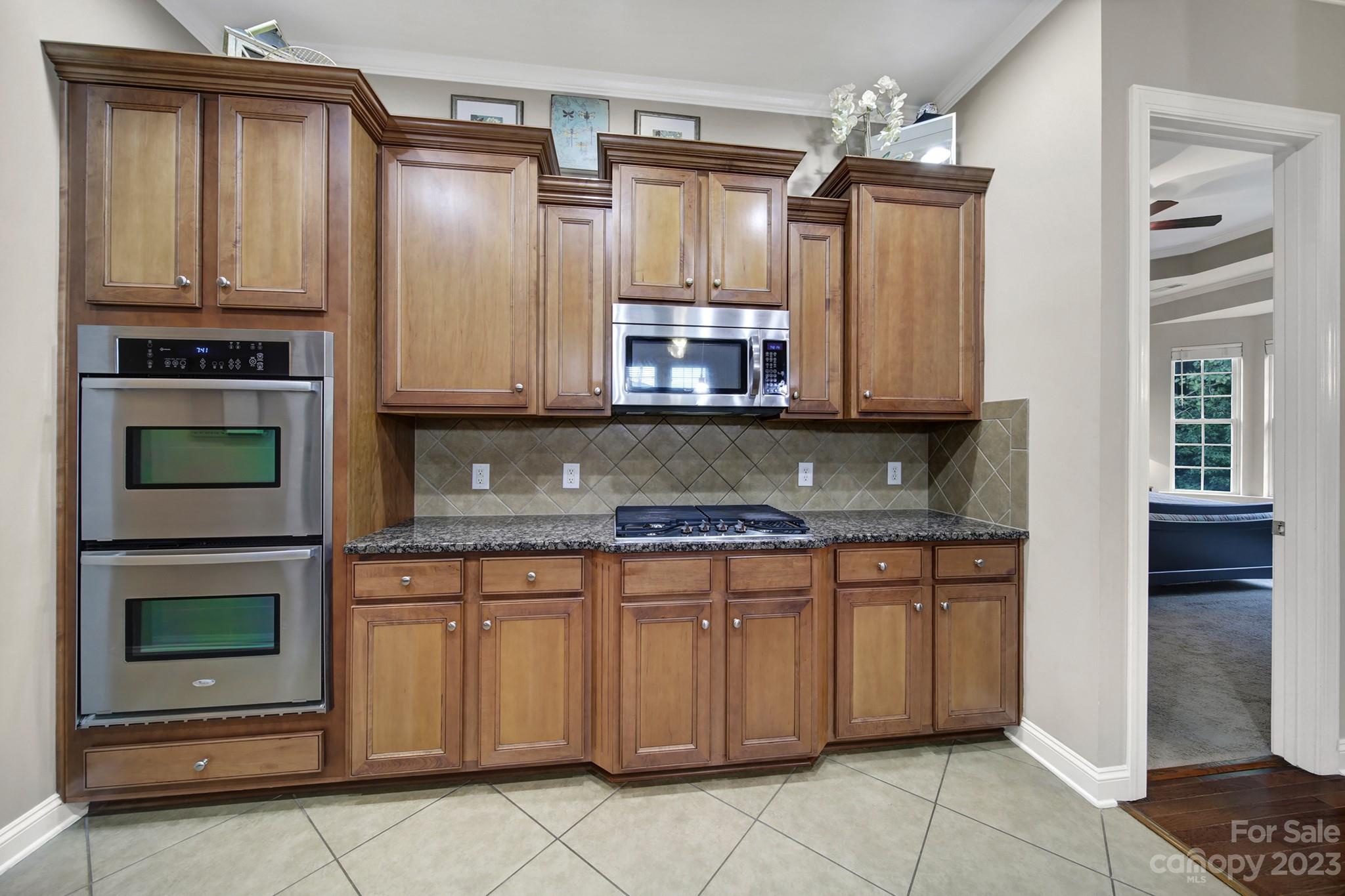 818 Treasure Court Fort Mill, SC 29708 - Photo 9 of 47 a kitchen with stainless steel appliances granite countertop a stove and a microwave