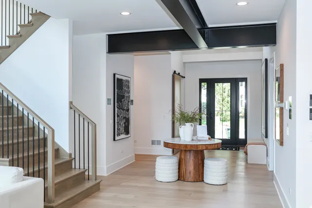 a view of a hallway with wooden floor and a dining room