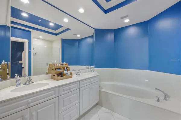 a bathroom with a tub a sink and mirror