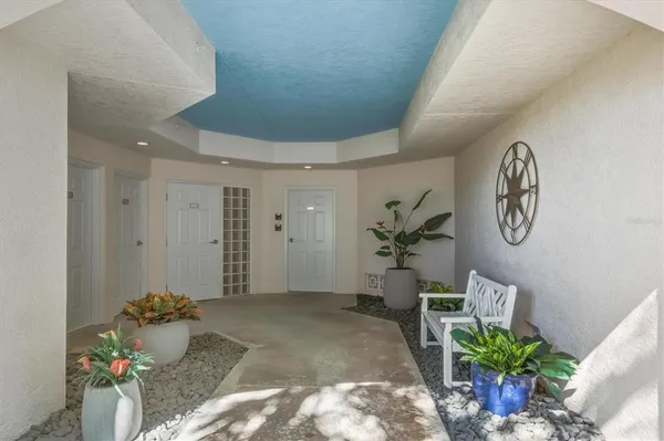 a hallway with painting on the wall and a potted plant