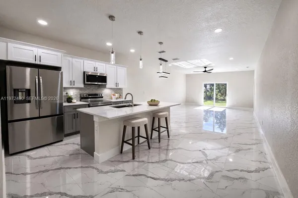 a kitchen with stainless steel appliances a refrigerator sink and microwave