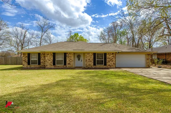 a front view of a house with a garden and yard