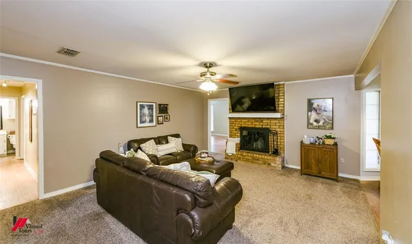 a view of a livingroom with wooden floor and a ceiling fan
