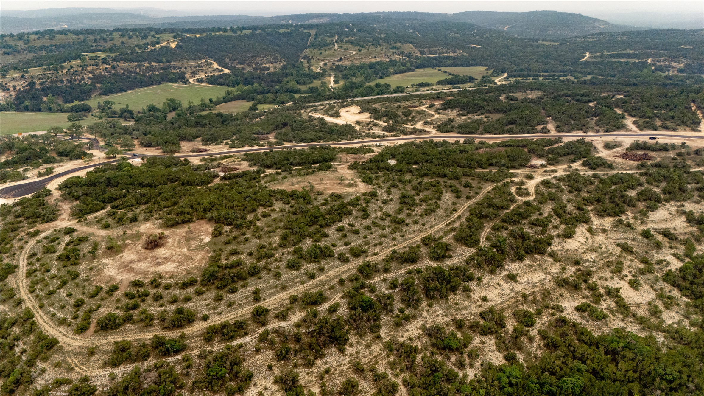 Lot 21 Ranch Road 165 Dripping Springs, TX 78620 - Photo 4 of 8 Expansive acreage featuring abundant mature tree coverage, varied terrain, and visible unpaved access paths