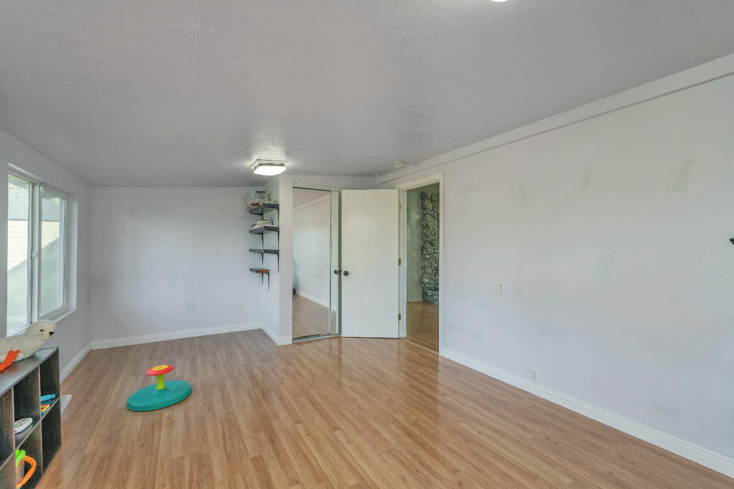 6261 Grizzly Flat Road Somerset, CA 95684 - Photo 44 of 63 an empty room with wooden floor and windows