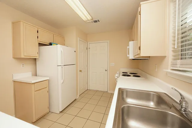 a kitchen with a refrigerator a stove a sink and a cabinets