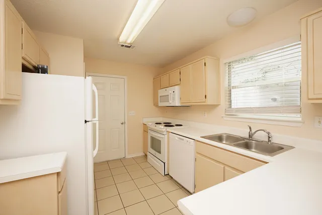 a kitchen with a sink a stove and a refrigerator