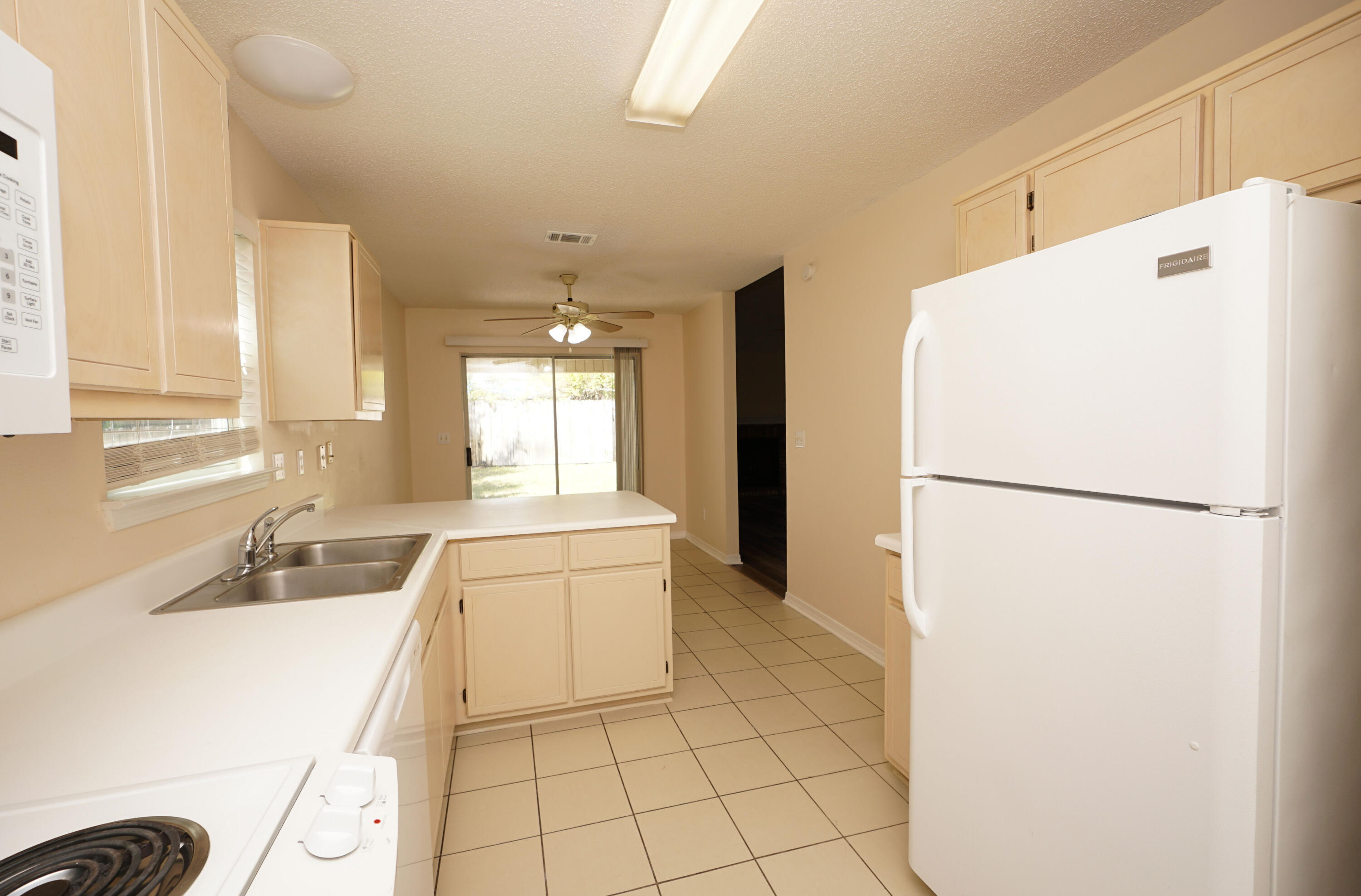 406 Springate Court Mary Esther, FL 32569 - Photo 18 of 41 a kitchen with a refrigerator sink stove and cabinets