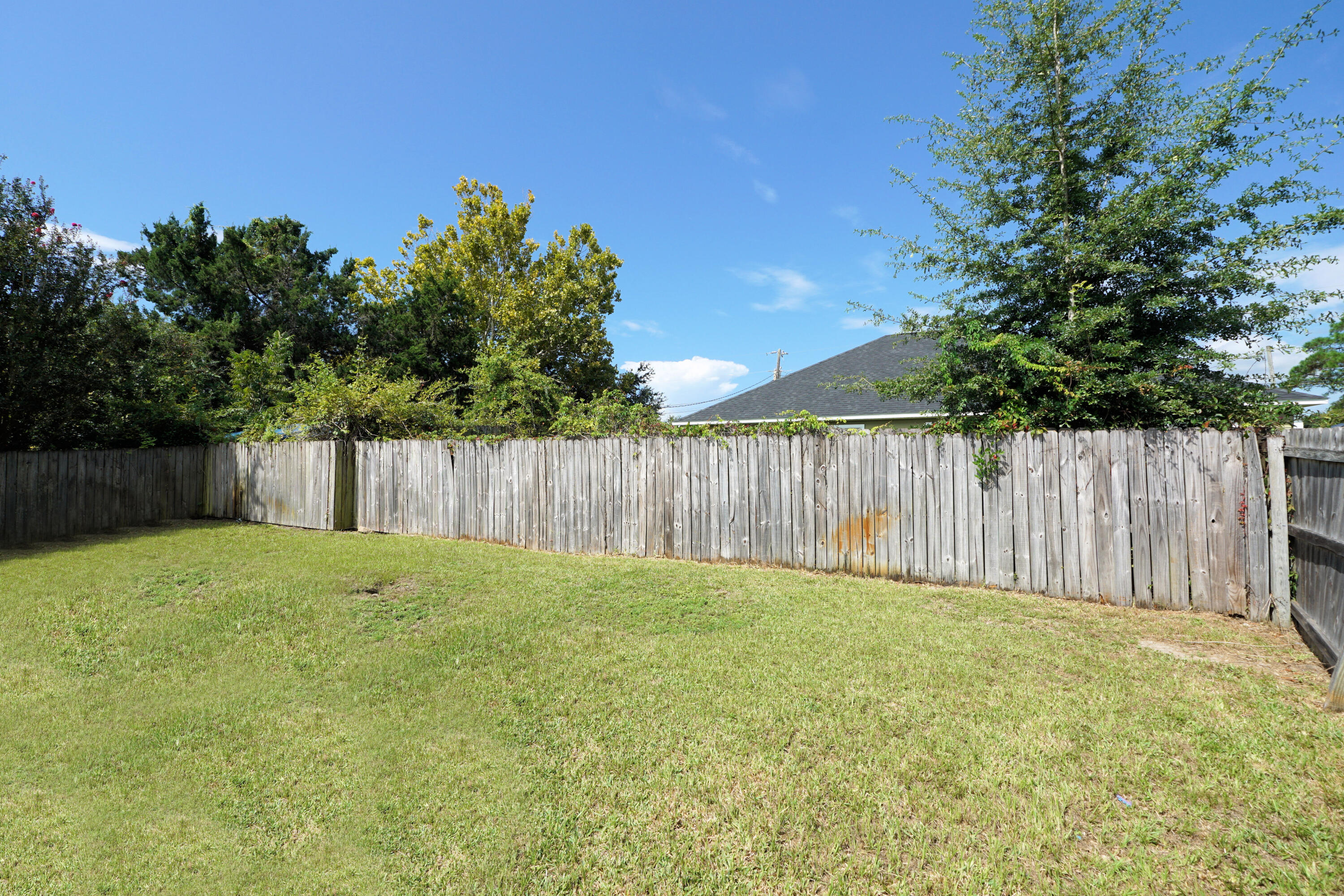 406 Springate Court Mary Esther, FL 32569 - Photo 36 of 41 a view of a backyard with large trees and wooden fence