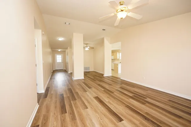 a view of a room with wooden floor and ceiling fan