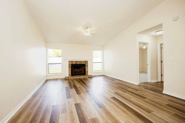 wooden floor in an empty room with a fireplace