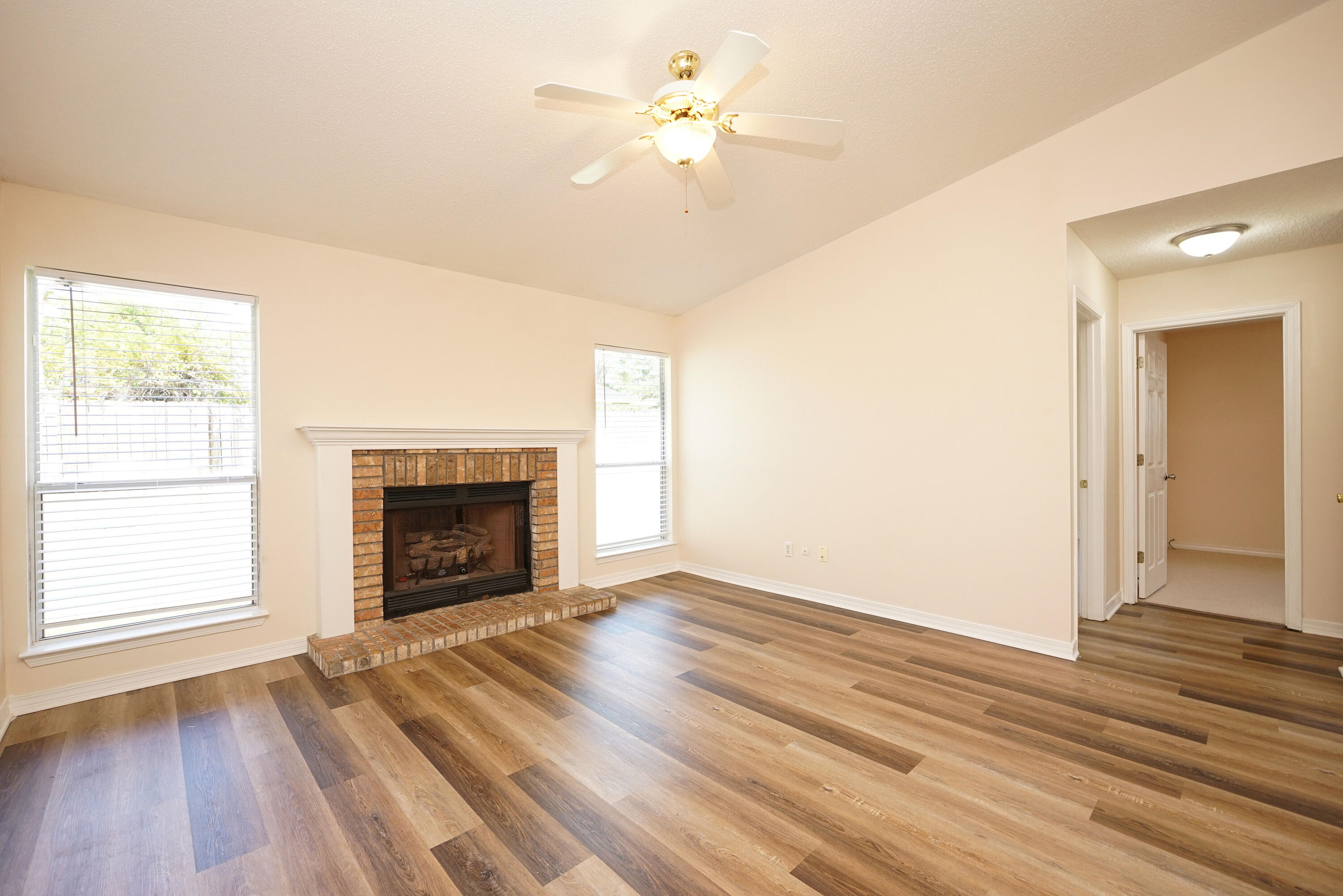 406 Springate Court Mary Esther, FL 32569 - Photo 8 of 41 an empty room with a fireplace and wooden floor