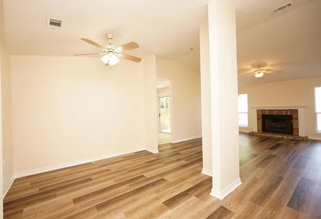 a view of empty room with wooden floor